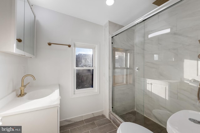 bathroom with vanity, toilet, and a shower with shower door