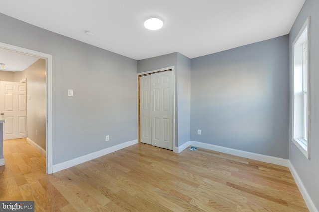 unfurnished bedroom with light hardwood / wood-style floors and a closet