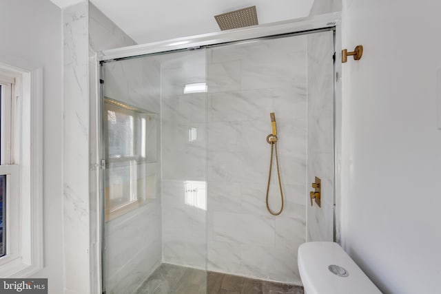 bathroom featuring walk in shower and toilet