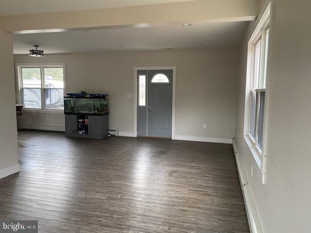 foyer entrance featuring dark wood-style flooring and baseboards