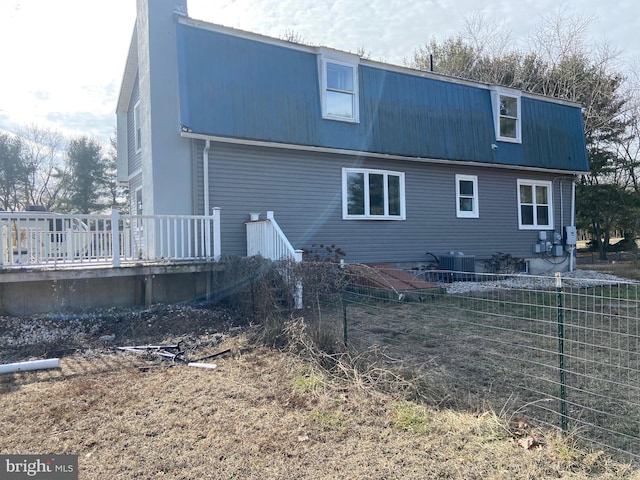 rear view of house with metal roof and a deck