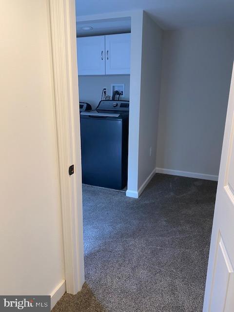 interior space with baseboards, washer / clothes dryer, and dark carpet