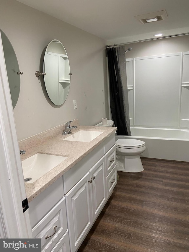 bathroom with toilet, visible vents, a sink, and wood finished floors