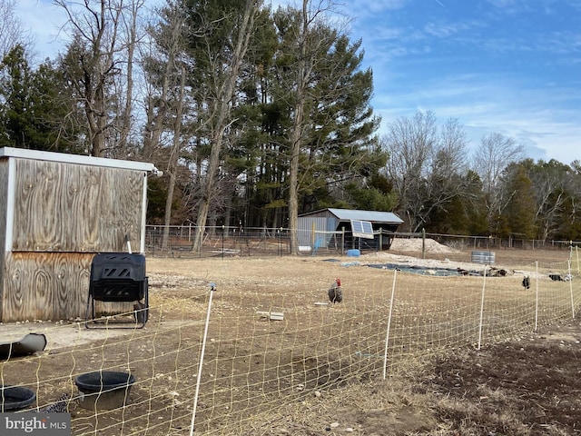 view of yard featuring an outdoor structure and fence