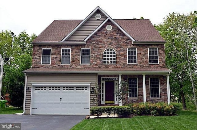 view of front of home with a front yard and a garage