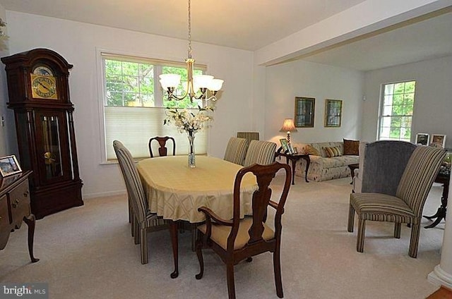 dining area with a chandelier and light colored carpet