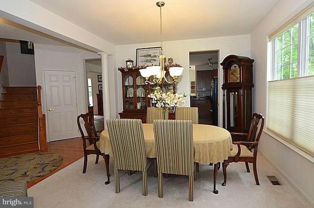 dining space with an inviting chandelier and decorative columns