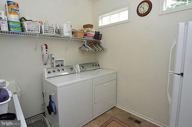 washroom featuring washer and dryer and light tile patterned flooring