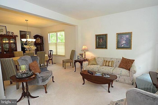 living room with light carpet and an inviting chandelier
