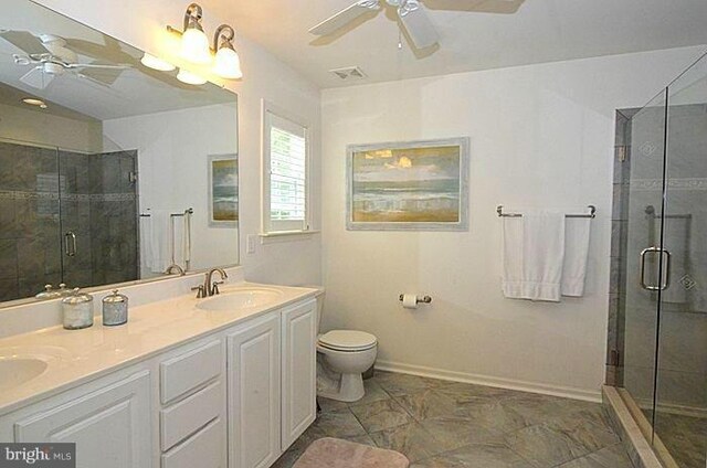 bathroom featuring toilet, ceiling fan, an enclosed shower, and vanity