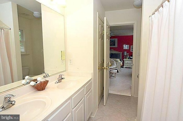bathroom featuring vanity, tile patterned flooring, and toilet