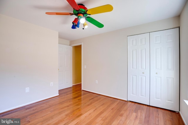 unfurnished bedroom with light hardwood / wood-style flooring, ceiling fan, and a closet