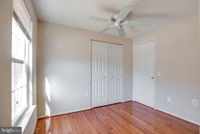 unfurnished bedroom featuring multiple windows, a closet, ceiling fan, and light hardwood / wood-style floors