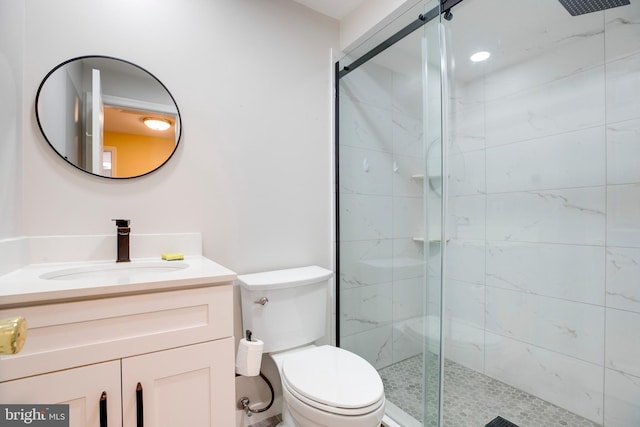 bathroom with vanity, toilet, and a shower with shower door