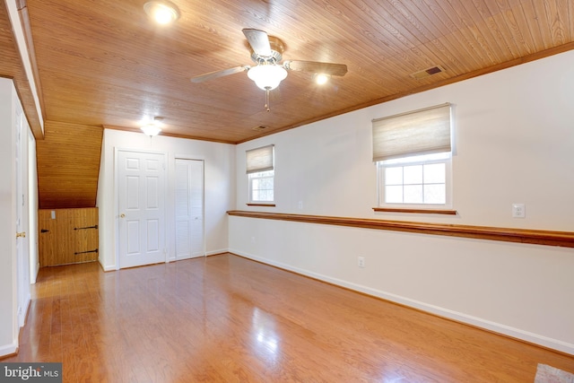 empty room with ceiling fan, wood ceiling, crown molding, and hardwood / wood-style floors