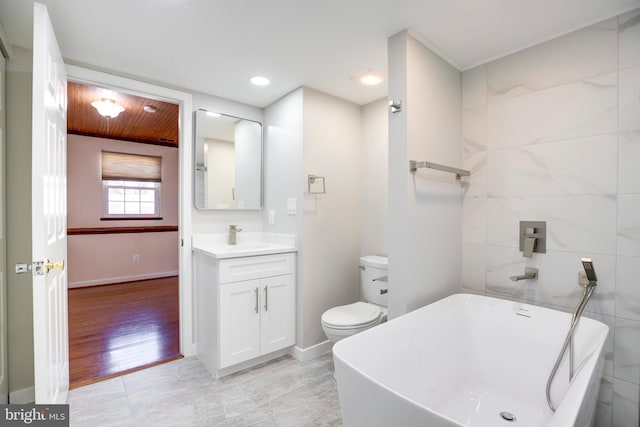 bathroom featuring vanity, toilet, and a tub