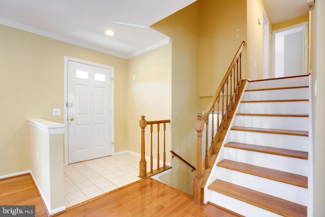 foyer featuring light wood-type flooring and crown molding