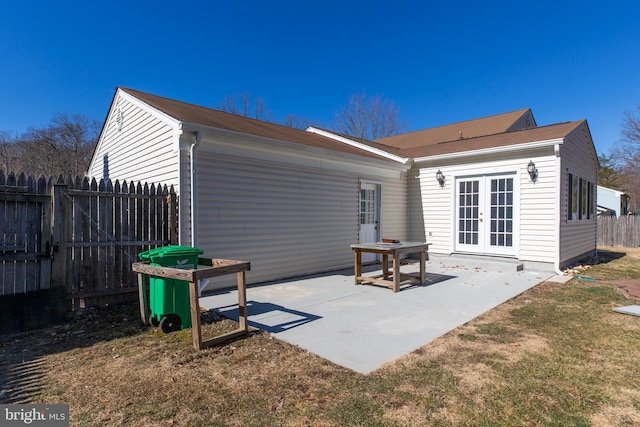 rear view of house featuring a patio, a yard, and french doors