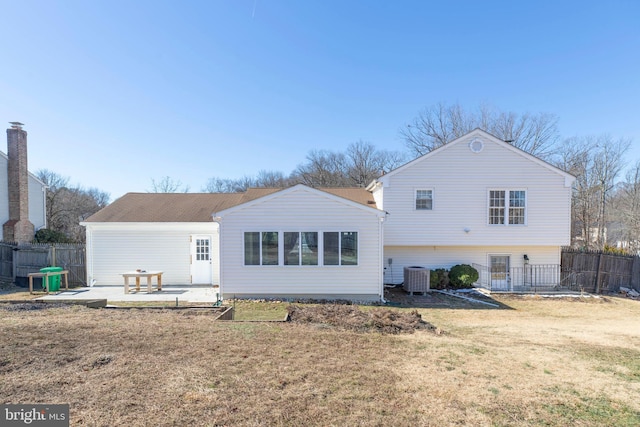 rear view of house with a patio, cooling unit, and a lawn