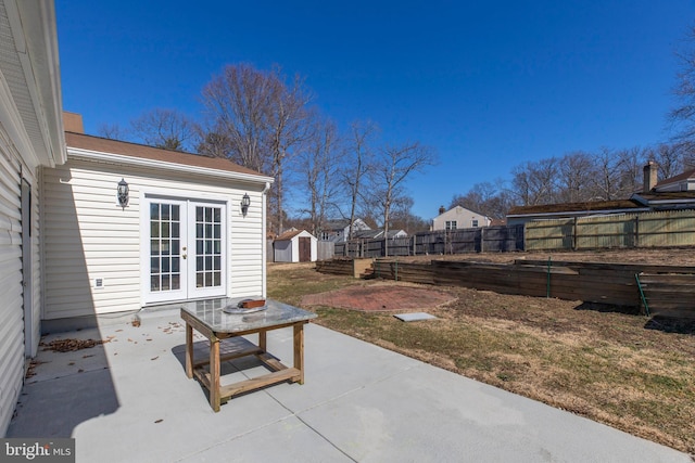 view of patio / terrace featuring french doors and a storage unit