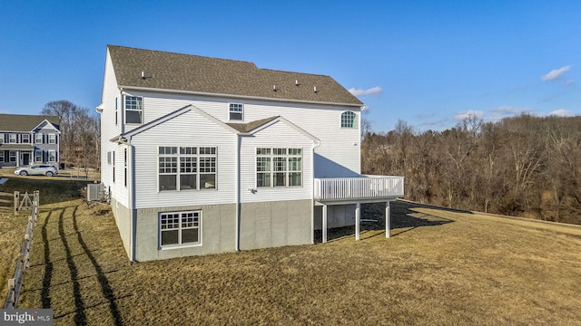 rear view of property with cooling unit, a yard, and a deck