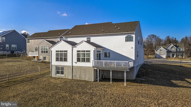 rear view of property with a wooden deck and a lawn