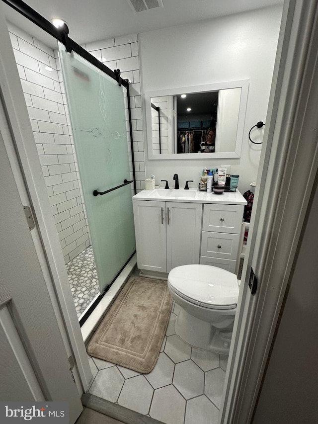 full bath featuring tile patterned floors, vanity, toilet, and a shower stall