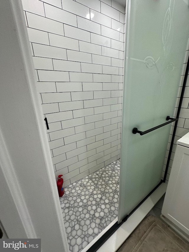 bathroom with a stall shower and tile patterned floors