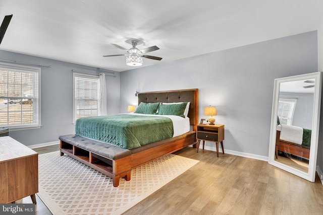 bedroom featuring light wood-type flooring, baseboards, and a ceiling fan