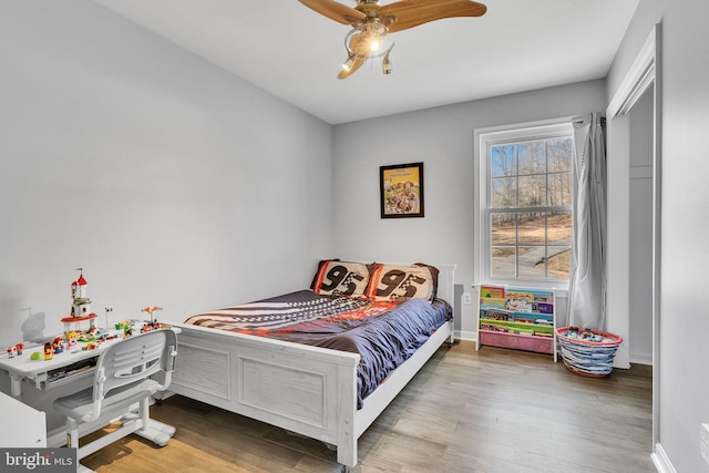 bedroom with wood finished floors, baseboards, and ceiling fan