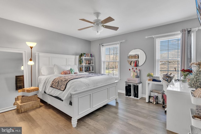 bedroom with baseboards, light wood-style floors, and a ceiling fan