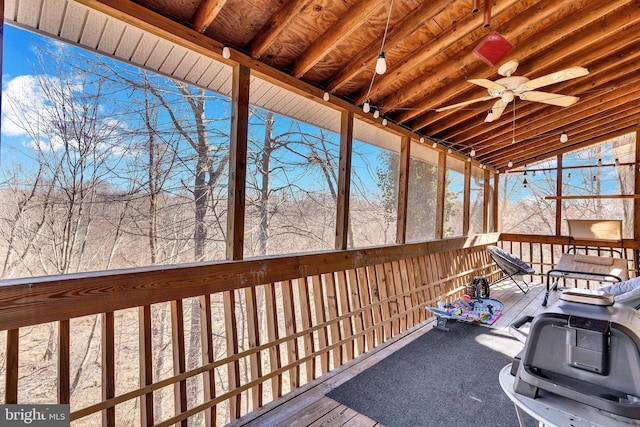 unfurnished sunroom featuring a ceiling fan