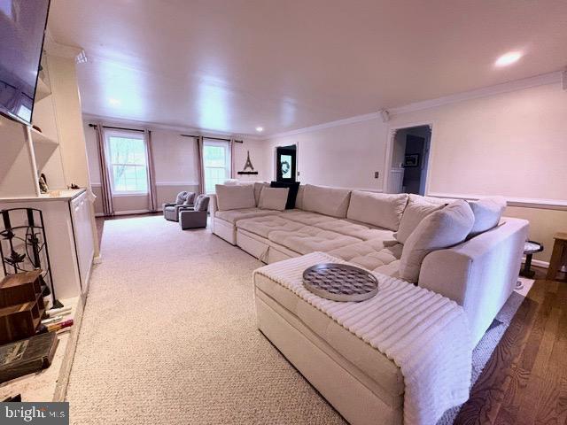 living area featuring recessed lighting and ornamental molding