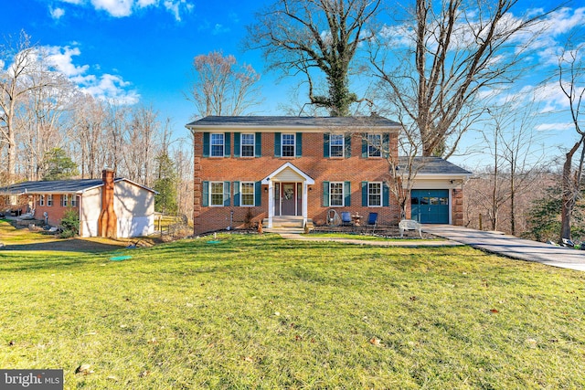 view of front of house with brick siding, concrete driveway, a front yard, and a garage