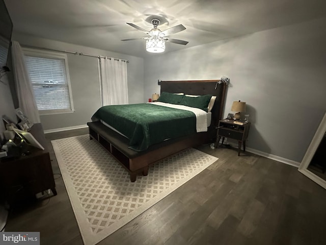 bedroom with dark wood-type flooring, baseboards, and a ceiling fan