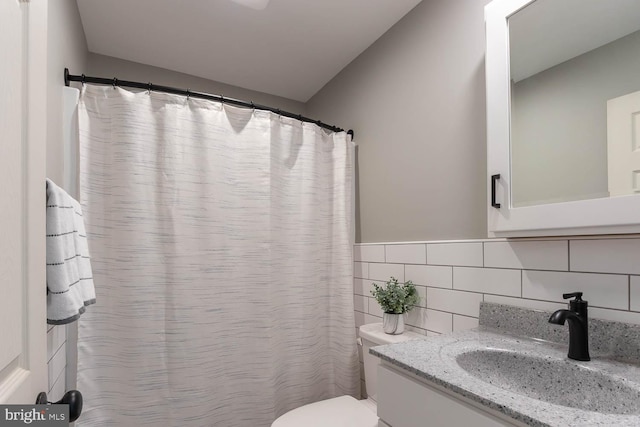 bathroom featuring tile walls, vanity, and toilet