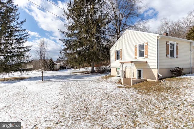 snow covered house with ac unit