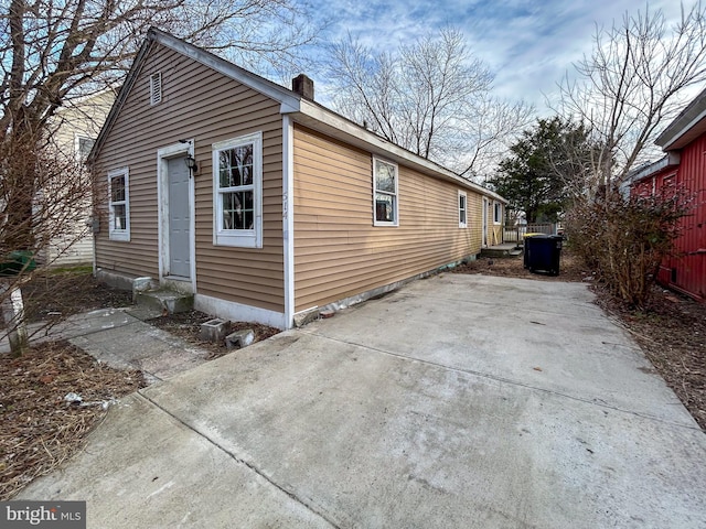 view of property exterior with entry steps and a chimney