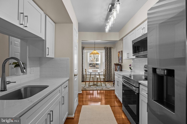 kitchen featuring stainless steel appliances, light stone countertops, sink, and white cabinets