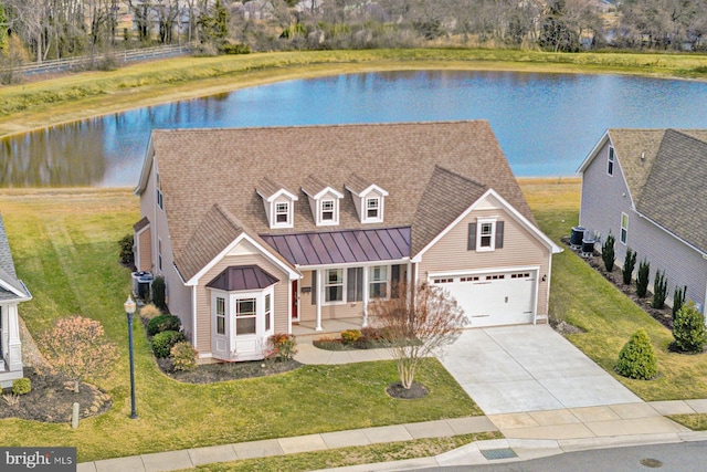 view of front of home featuring central AC unit, a garage, a front lawn, and a water view