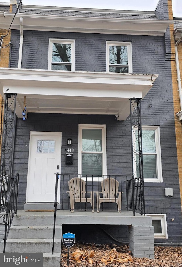 view of front facade with covered porch and brick siding