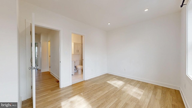 unfurnished bedroom featuring light wood-style floors, recessed lighting, baseboards, and ensuite bathroom