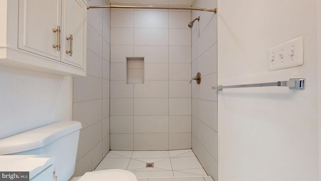 bathroom featuring vanity, a tile shower, and toilet