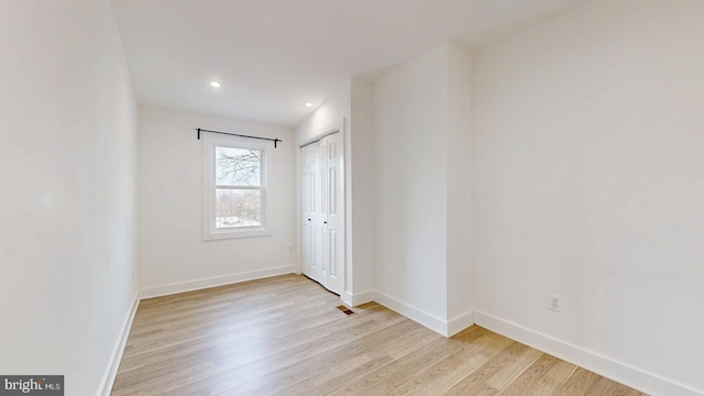 unfurnished room featuring recessed lighting, wood finished floors, visible vents, and baseboards