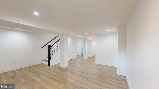 finished below grade area featuring baseboards, stairway, light wood-type flooring, and recessed lighting