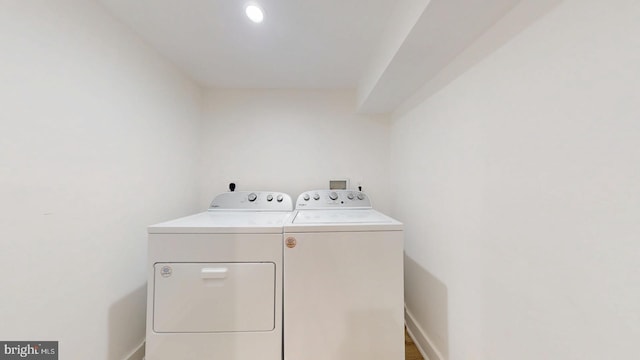 washroom with laundry area, washer and clothes dryer, and baseboards