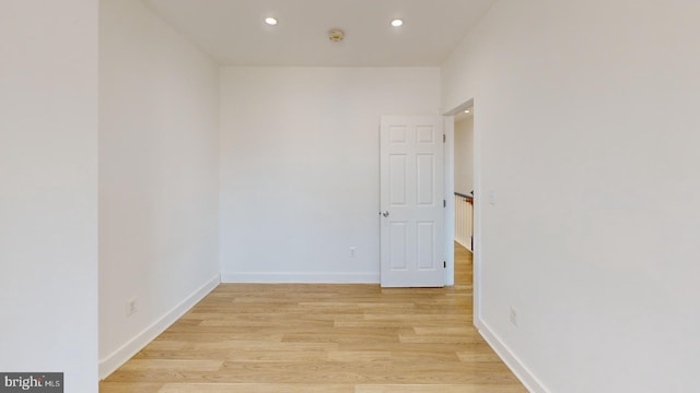 spare room featuring light wood-type flooring, baseboards, and recessed lighting