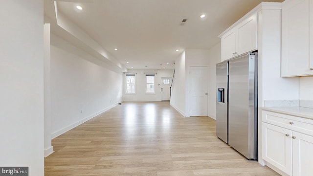 kitchen featuring recessed lighting, white cabinetry, light wood finished floors, and stainless steel fridge with ice dispenser