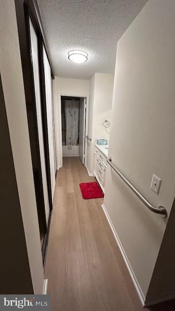 hallway featuring a textured ceiling and light wood-type flooring