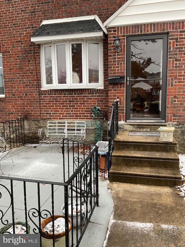 doorway to property with brick siding